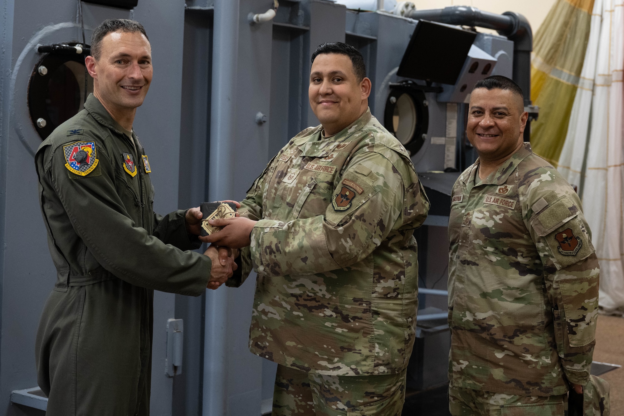 U.S. Air Force Col. Tyler Ellison, 47th Flying Training Wing commander, and Chief Master Sgt. Lester J. Largaespada, 47th FTW command chief, present a first quarter award at Laughlin Air Force Base, May 2, 2025. The quarterly awards ceremony honored Airmen and civilians who demonstrated exceptional performance, leadership, and mission impact across the wing. (U.S. Air Force photo by Airman 1st lass Harrison Sullivan)