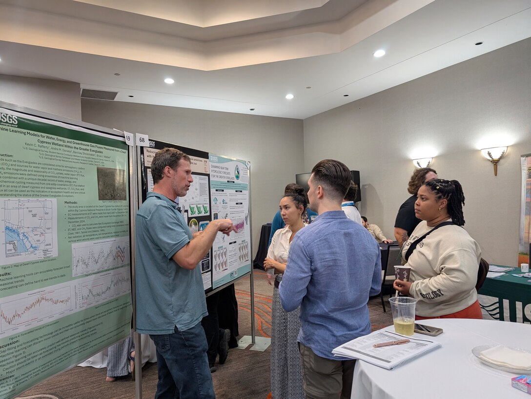 RECOVER team members, Tasso Cocoves, Nate Dorn, Marisa Martinez, and Kiah Williams discuss Marisa's poster, Reducing uncertainty of wading bird colony size predictions with the Everglades Vulnerability Analysis (EVA) tool at the Greater Everglades Ecosystem Restoration Conference.