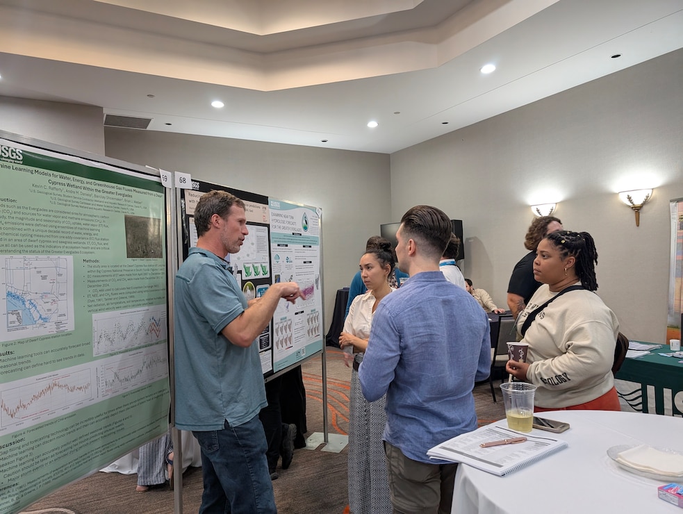 RECOVER team members, Tasso Cocoves, Nate Dorn, Marisa Martinez, and Kiah Williams discuss Marisa's poster, Reducing uncertainty of wading bird colony size predictions with the Everglades Vulnerability Analysis (EVA) tool at the Greater Everglades Ecosystem Restoration Conference.