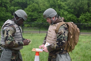 Senior Airman Giscard Foncham, 931st Maintenance squadron crew chief, and Senior Airman Dante Jasinskas, 931st Aircraft Maintenance Squadron aerospace propulsion technician, apply simulated M-8 Chemical Detection Paper at points around the base perimeter during exercise Lethal Stack May 7, 2025, at McConnell Air Force Base, Kansas