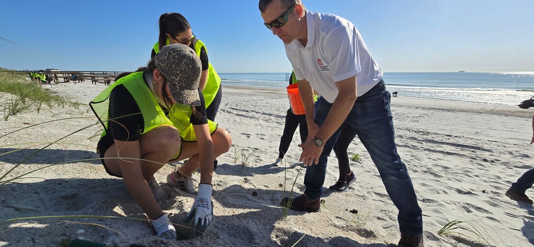 U.S. Army Corps of Engineers, Chief of Water Resources, Will Reilly guides volunteers from the Jacksonville Jaguars front office to plant bitter panic grass and sea oats along the Duval County Shoreline, near Hanna Park.