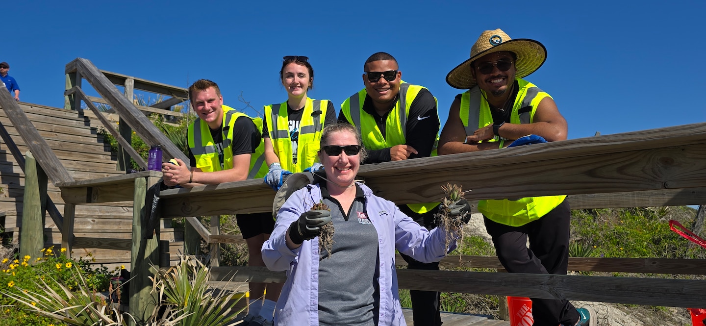 U.S. Army Corps of Engineers, Jacksonville District Invasive Species Biologist, Jessica Spencer shows the removal of invasive kalanchoe or “mother of millions” from dunes near Hanna Park in Duval County, during a partnership cleanup and planting event with volunteers from the Jacksonville Jaguars front office staff.