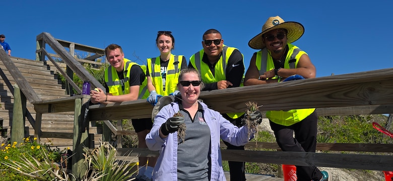 U.S. Army Corps of Engineers, Jacksonville District Invasive Species Biologist, Jessica Spencer shows the removal of invasive kalanchoe or “mother of millions” from dunes near Hanna Park in Duval County, during a partnership cleanup and planting event with volunteers from the Jacksonville Jaguars front office staff.