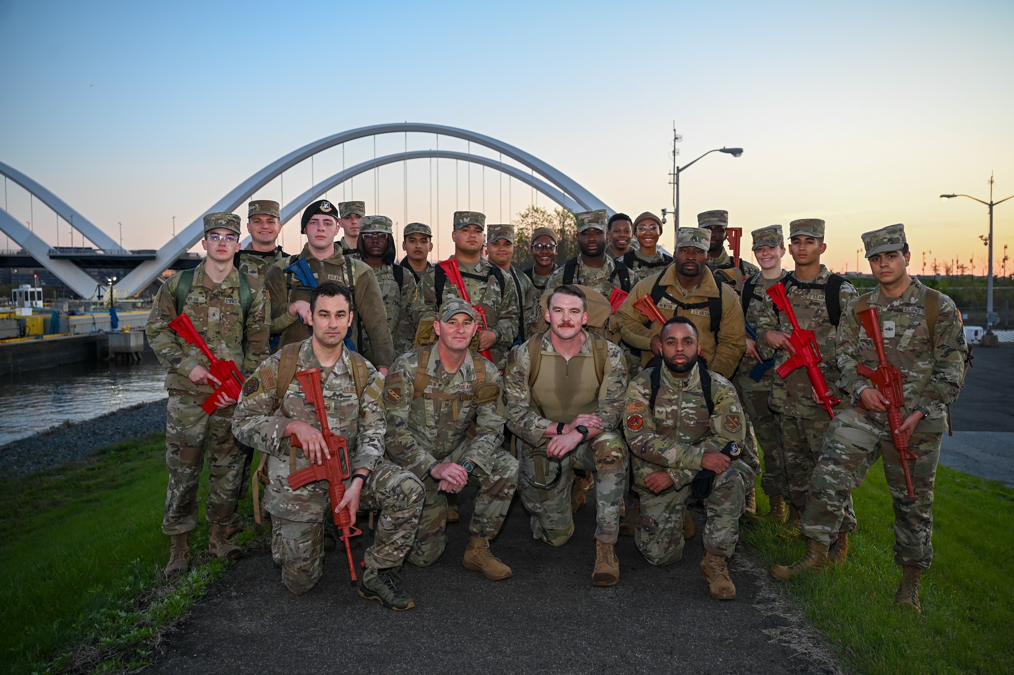 First Term Enlisted Course leaders and  first term enlisted members of the U.S. Air Force and U.S. Space Force gather for a photo after a five kilometer ruck at dawn in front of the Frederick Douglass Memorial Bridge on JBAB, Washington, D.C., April 18, 2025. The ruck march was a part of FTEC and preceded a training exercise designed to challenge and develop new Airmen and Guardians with hand-on tactical experience to ensure mission readiness across the force. (U.S. Air Force photo by Airman 1st Class Shanel Toussaint)