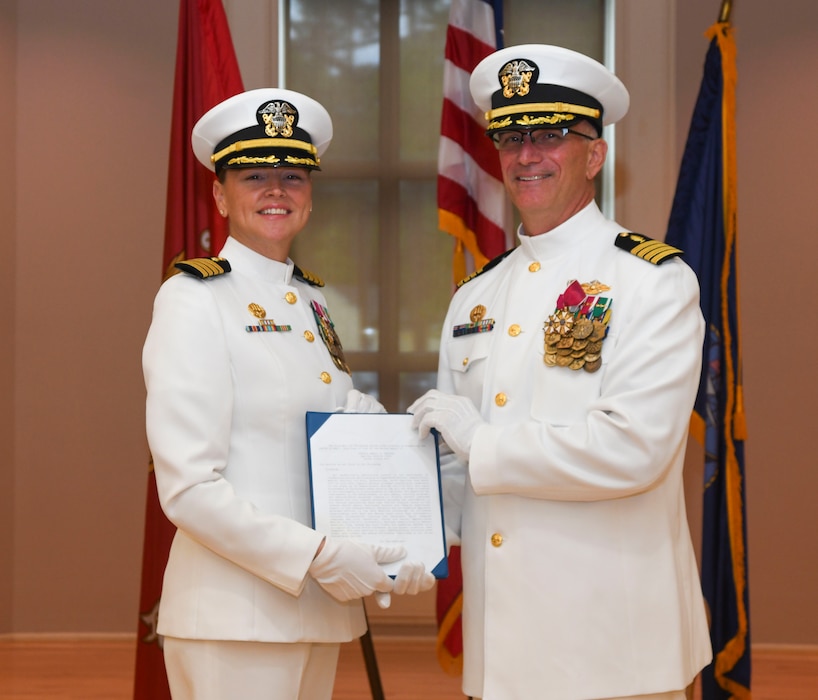 Capt. Anja Dabelic, left, NMCCL commanding officer, poses for an awards photo with Capt. Darryl Arfsten, EMF-Kilo commanding officer, during the Expeditionary Medical Facility Kilo change of command ceremony at Marston Pavillion, on May 9, 2025. EMF-Kilo is the readiness platform attached to Navy Medicine Readiness and Training Command Camp Lejeune and is comprised of approximately 400 personnel ready to deploy field hospital capabilities during humanitarian or combat mission.