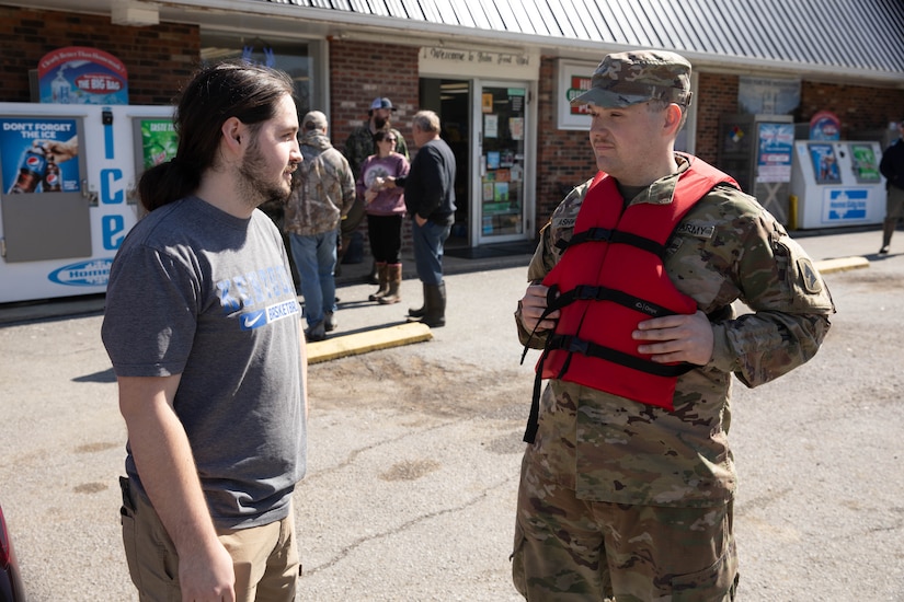 Spc. Nathan Ashworth talks with Boston, Ky. resident Collin Williamson, Apr. 7, 2025. Soldiers with Charlie Battery, 2nd Battalion, 138th Field Artillery Brigade based in Bardstown, work with local officials to aid Nelson Countians stranded because of flood waters. The catastrophic flooding is the result of several days of heavy rainfall across the commonwealth. (U.S. Army National Guard Photo by Milt Spalding)
