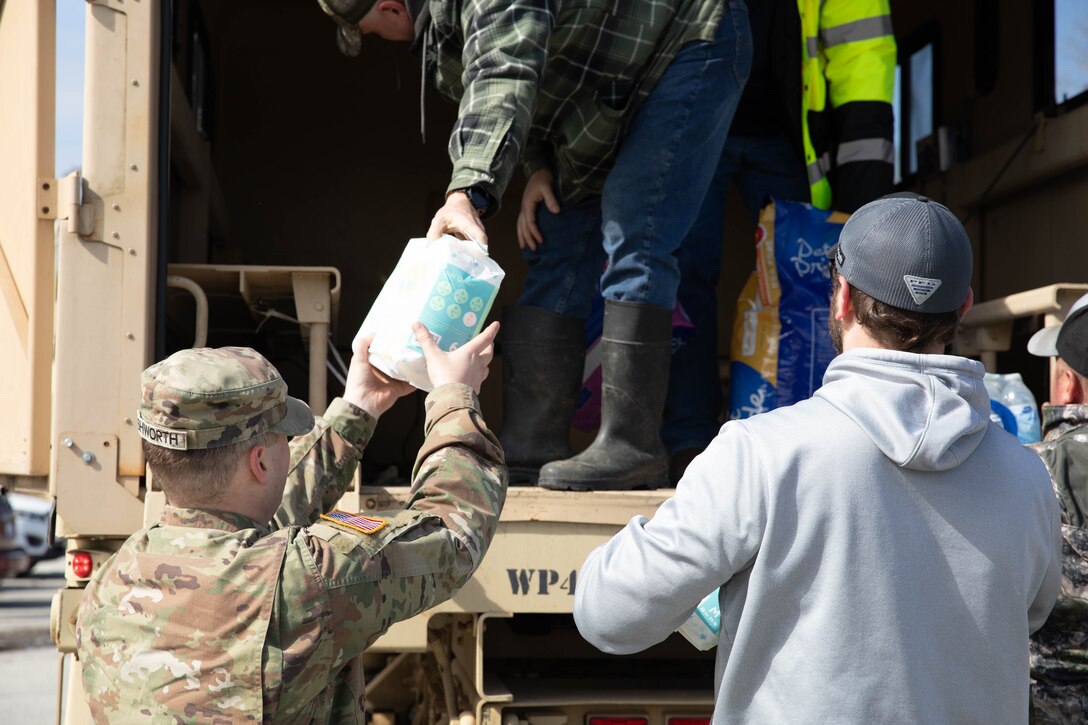 Spc. Nathan Ashworth unloads supplies to help the residents of Boston, Ky., Apr. 7, 2025. Soldiers with Charlie Battery, 2nd Battalion, 138th Field Artillery Brigade based in Bardstown, work with local officials to aid Nelson Countians stranded because of flood waters. The catastrophic flooding is the result of several days of heavy rainfall across the commonwealth. (U.S. Army National Guard Photo by Milt Spalding)