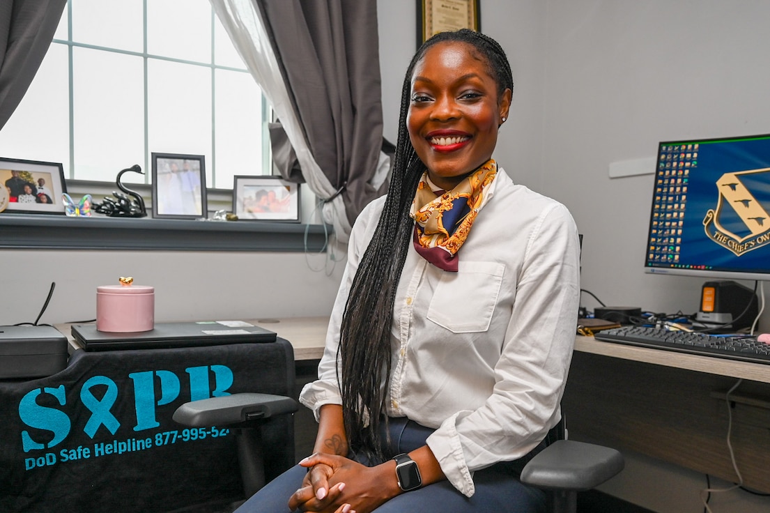 A photo of a woman sitting at her desk facing the camera in office