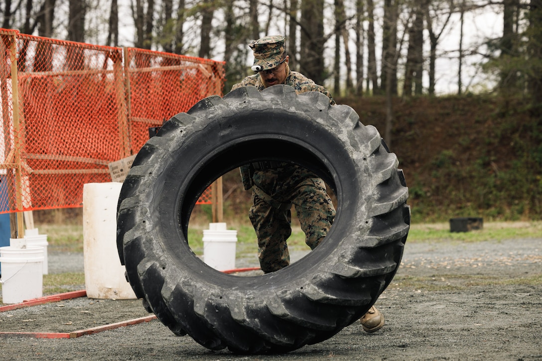 U.S. Marine Corps Staff Sgt. Robert Germanelo, a data systems chief with Marine Corps Air Station Miramar, conducts a tire flip as a part of the multi-weapon match during the Marine Corps Championships hosted by Weapons Training Battalion, on Marine Corps Base Quantico, Virginia, April 12, 2025. This competition brings together top shooters from regional marksmanship events to test their skills in precision rifle, action rifle, action pistol, and multi-gun action shooting. It continues the legacy of the Marine Corps Shooting Team, which has upheld marksmanship excellence since the early 1900s and reinforces the Corps' commitment to marksmanship as a core warfighting skill. (U.S. Marine Corps photo by Cpl. Joshua Barker)