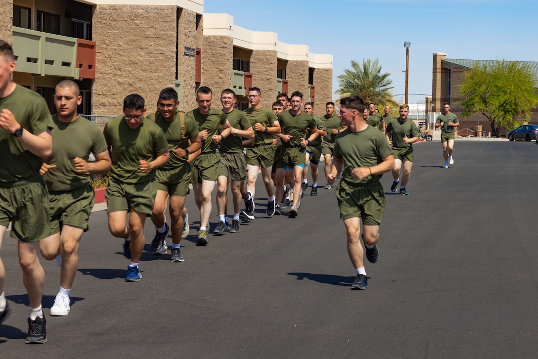 U.S. Marine Corps Pfc. Aden Sanders, right, an Ohio native, student with Marine Corps Communication-Electronics School, Training Command, Training and Education Command, speaks to Marines during unit physical training at Marine Corps Air Ground Combat Center, Twentynine Palms, California, May 1, 2025. Physical training helps Marines build the strength, endurance, and the cohesion amongst one another needed to maintain peak operational readiness. (U.S. Marine Corps photo by Lance Cpl. Saige Steiber)