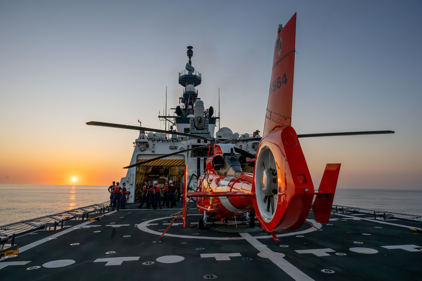 U.S. Coast Guard Cutter Kimball (WMSL 756) and Helicopter Interdiction Tactical Squadron (HITRON) crewmembers secure an embarked MH-65 Dolphin helicopter following flight operations while patrolling the Eastern Pacific Ocean, March 7, 2025. The HITRON aircrews are trained to employ airborne use of force to interdict non-compliant vessels during counter-drug operations. (U.S. Coast Guard photo by Petty Officer 3rd Class Austin Wiley)