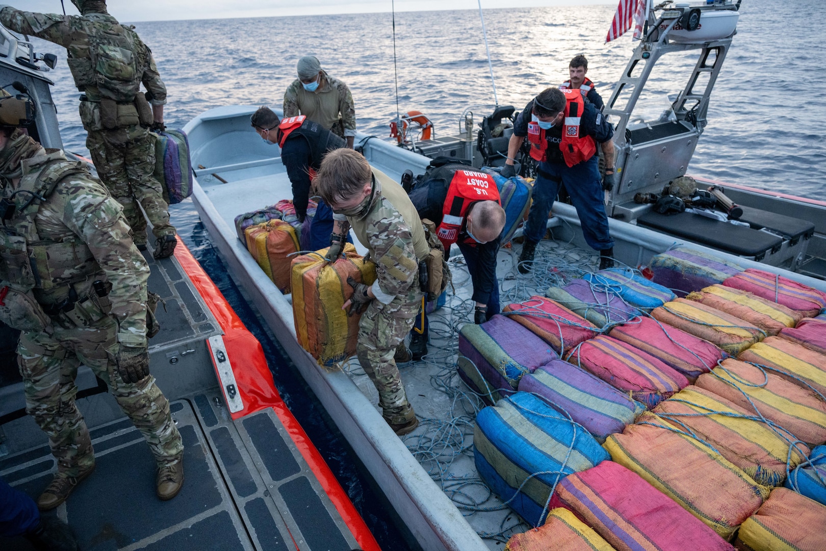 Members of Tactical Law Enforcement Team South (TACLET) and crewmembers from U.S. Coast Guard Cutter Kimball (WMSL 756) transfer 68 bales of cocaine weighing approximately 2,280 kilograms from an interdicted suspected drug smuggling vessel after law enforcement operations in the Eastern Pacific Ocean, April 17, 2025. TACLET teams deploy around the world to combat narcotics smuggling, aiding the effort to stop illegal drugs from entering the United States. (U.S. Coast Guard photo by Petty officer 3rd Class Austin Wiley)