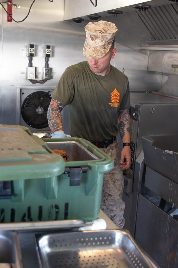 U.S. Marine Corps Gunnery Sgt. Taylor J. Dagostino, mess management chief, Headquarters Company, 23rd Marine Regiment, 4th Marine Division, prepares food for the warrior meal at Integrated Training Exercise 4-24, Marine Corps Air-Ground Combat Center, Twentynine Palms, California, June 23, 2024. Active and reserve component integration is vital to sharing knowledge and demonstrating how the two support each other. Reserve Marines and Sailors have come together from across the nation to form an integrated Marine Air-Ground Task Force to take part in a live-fire, combined arms exercise that will better prepare Marine Forces Reserve in its mission to augment and reinforce the active component. (U.S. Marine Corps photo by Orion Stpierre)