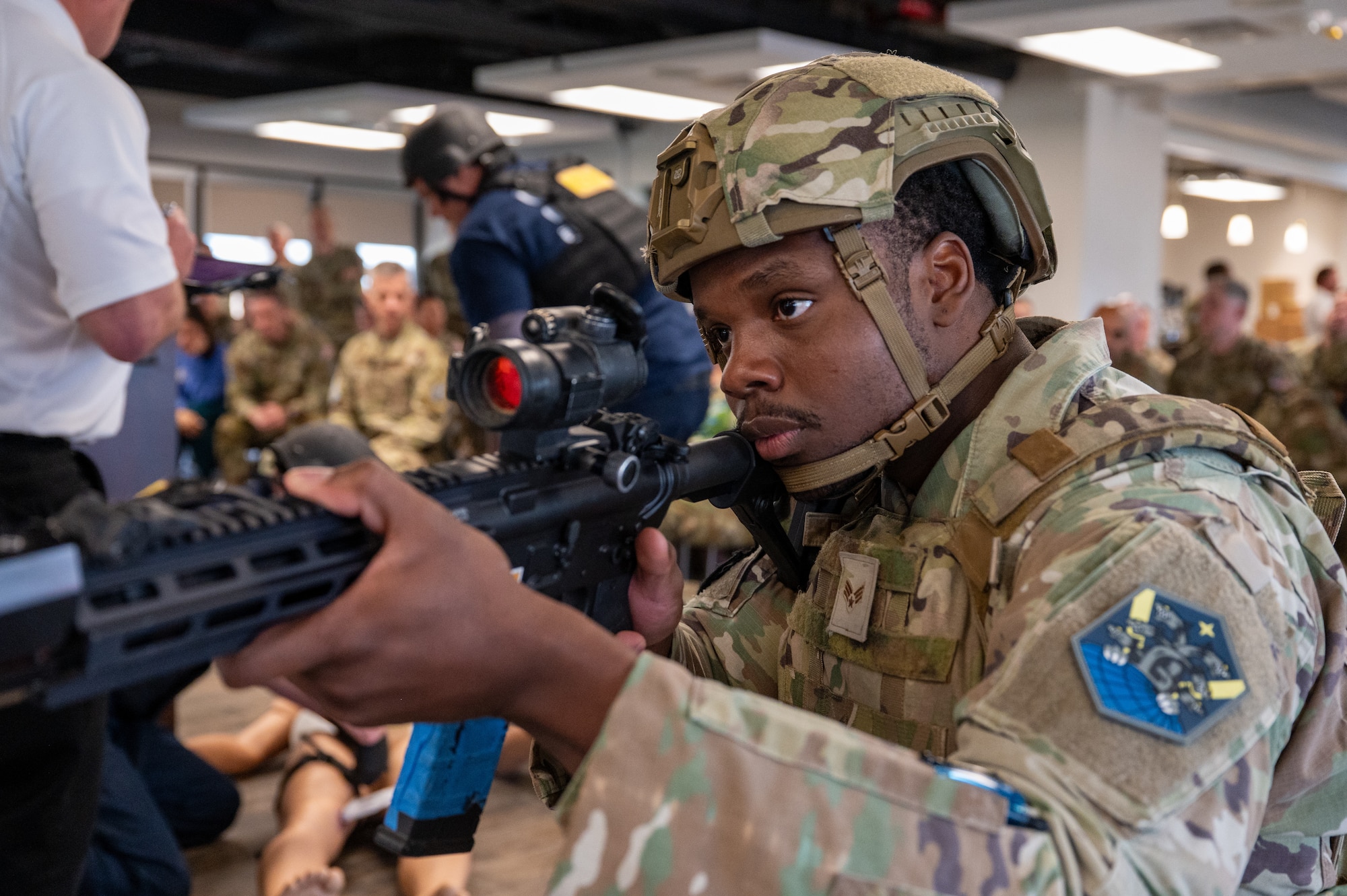50th Security Forces Squadron airman points a training rifle while guarding a 50th Civil Engineer Squadron firefighter during an active shooter exercise.