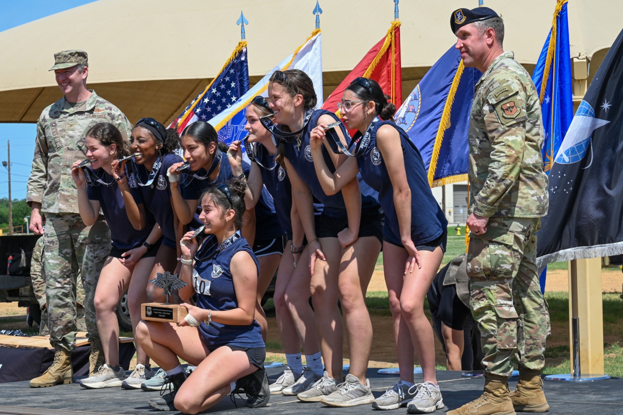 young ladies biting their medals