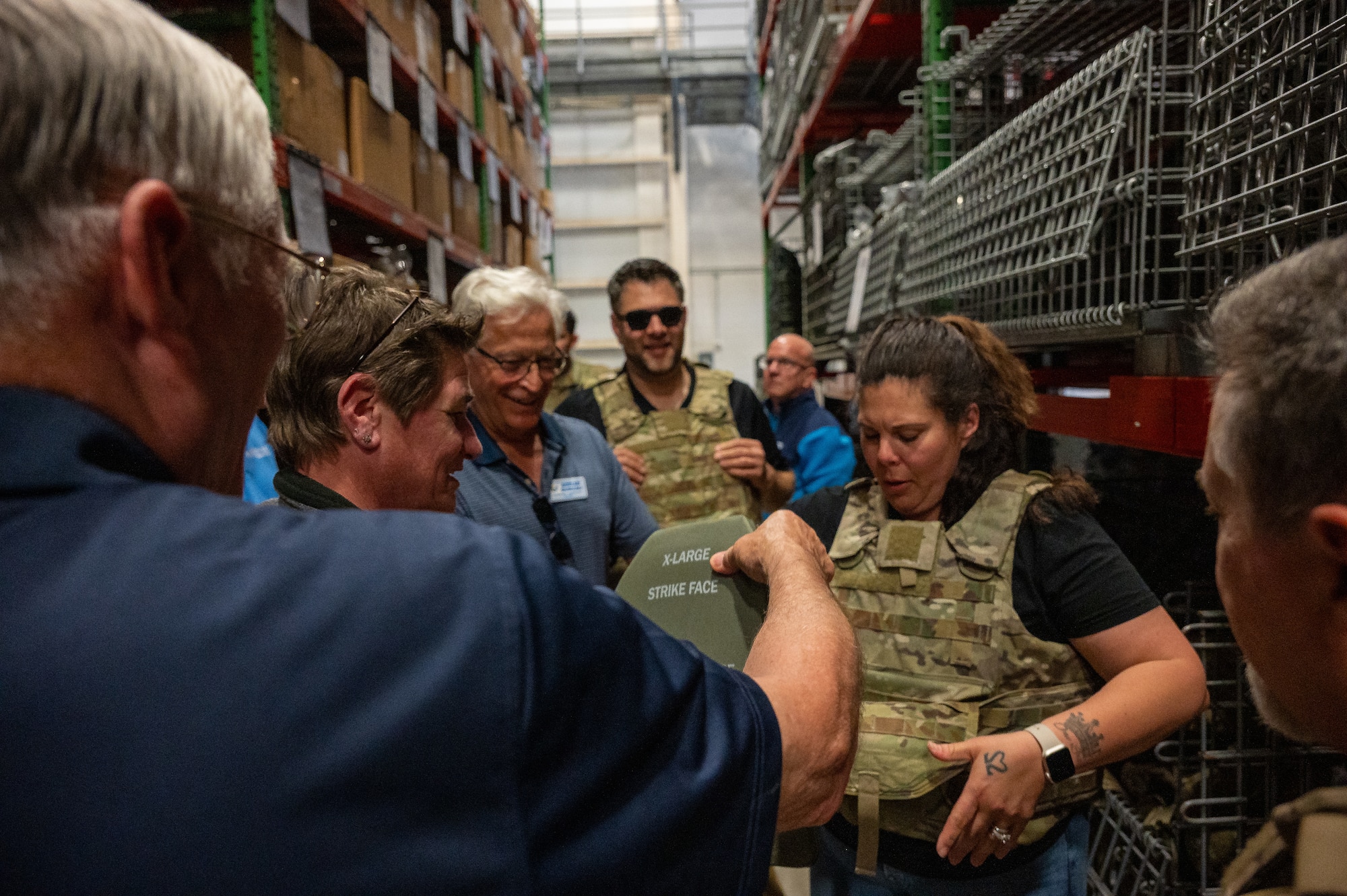 Team Dover Honorary Commanders try on plate carriers during their tour of the 436th Logistics Readiness Squadron at Dover Air Force Base, Delaware, May 7, 2025. Honorary Commanders received a tour of the different units under the 436th Mission Generation Group to learn about their mission.