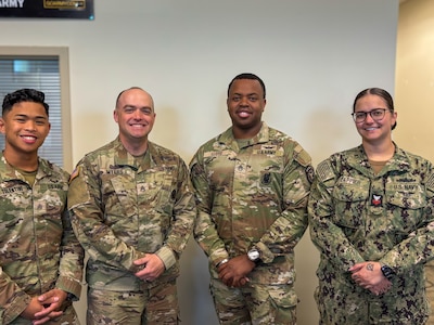 Four recruiters standing together at a recruiting station.