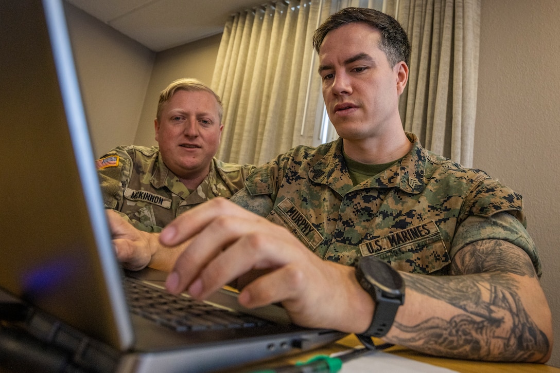 U.S. Army Capt. William McKinnon, left, cyber mission element lead, Florida Army National Guard, and U.S. Marine Corps Sgt. Thane Murphy, intelligence analyst, Defensive Cyberspace Operations Internal Defensive Measures, work through simulated cyber threats during exercise Southern Defender 25 in Augusta, Georgia, May 6, 2025. This exercise pushes teams to identify vulnerabilities, respond to adversary injects, and coordinate actions across 28 teams in 15 locations consisting of 20 participating countries in real time. (U.S. Marine Corps photo by Sgt. Samuel Qin)