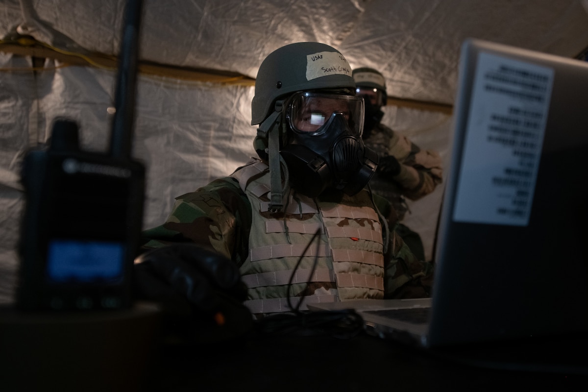 Staff Sgt. Scott Cragle Jr., 22nd Air Refueling Wing contracting specialist, works on his laptop in mission-oriented protective posture gear during Exercise Lethal Stack at McConnell Air Force Base, Kansas, May 7, 2025. Lethal Stack was designed to train Airmen to work despite chemical, biological, radiological and nuclear (CBRN) hazards and degraded communications. (U.S. Air Force photo by Senior Airman Amelio Brown)