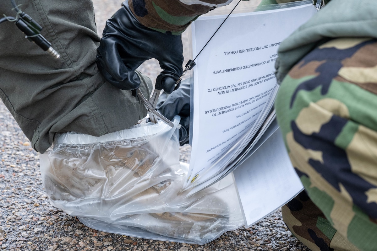 A cover is cut off a boot during Exercise Lethal Stack at McConnell Air Force Base, Kansas, May 7, 2025. Boot covers are worn as part of level four mission-oriented protective posture gear, which protects against chemical, biological, radiological and nuclear threats. (U.S. Air Force photo by Airman 1st Class Patrick O’Neill)