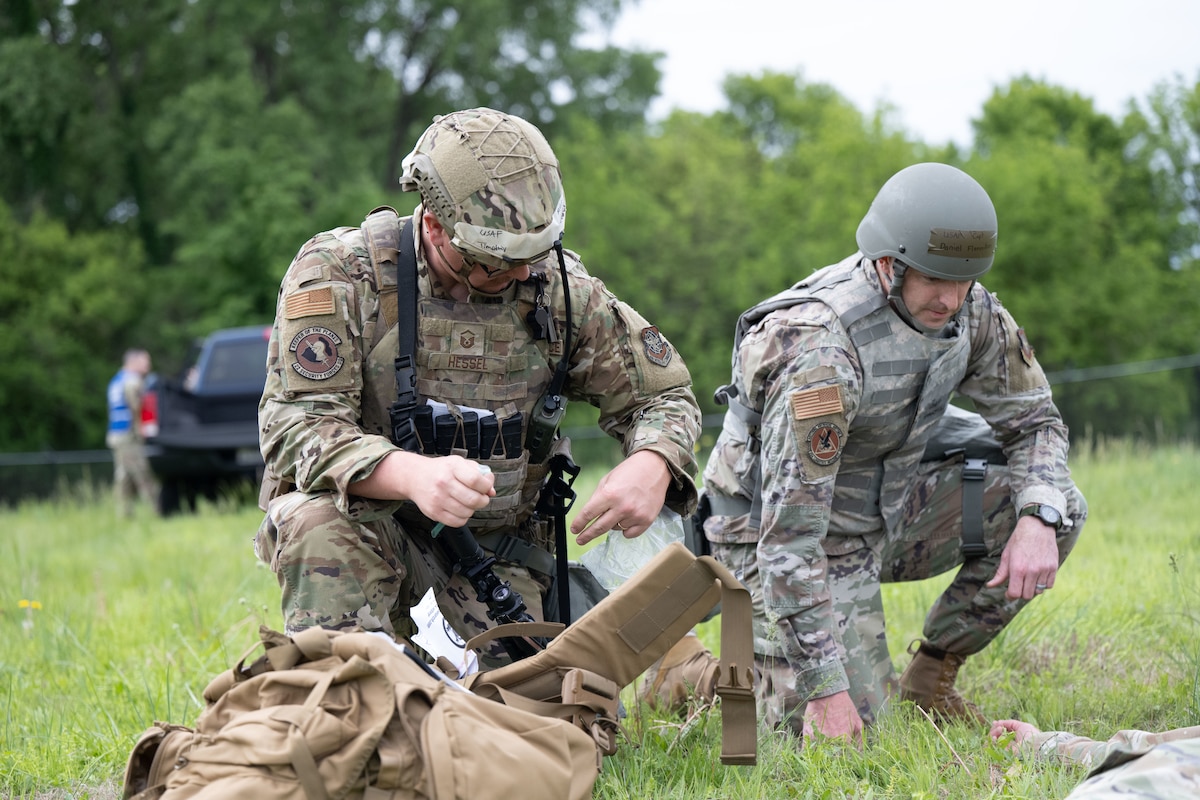 From left, Master Sgt. Timothy Hessel, 22nd Security Forces Squadron patrolman, and Capt. Daniel Flenniken, 22nd Logistics Readiness Squadron director of operations, assists a simulated downed airman during exercise Lethal Stack at McConnell Air Force Base, Kansas, May 6, 2025.  The weeklong exercise tested units’ ability to generate aircraft and operate within a contested environment to increase lethality, survivability and agility.  (U.S. Air Force photo by Senior Airman Felicia Przydzial)