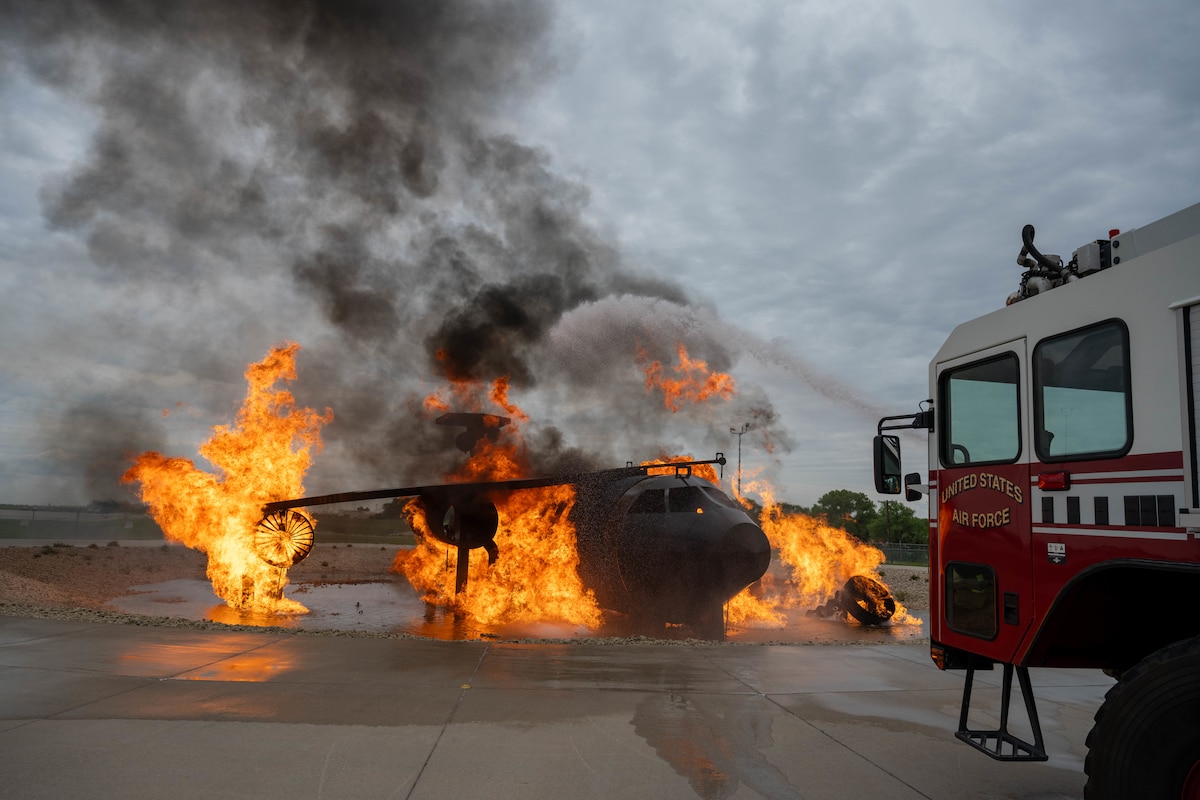 A firetruck blasts water toward a flame-engulfed aircraft during Exercise Lethal Stack at McConnell Air Force Base, Kansas, May 6, 2025. Lethal Stack aircraft practiced rapidly pivoting into theater, providing critical air refueling capabilities for allies and partners. (U.S. Air Force photo by Airman 1st Class Patrick O’Neill)