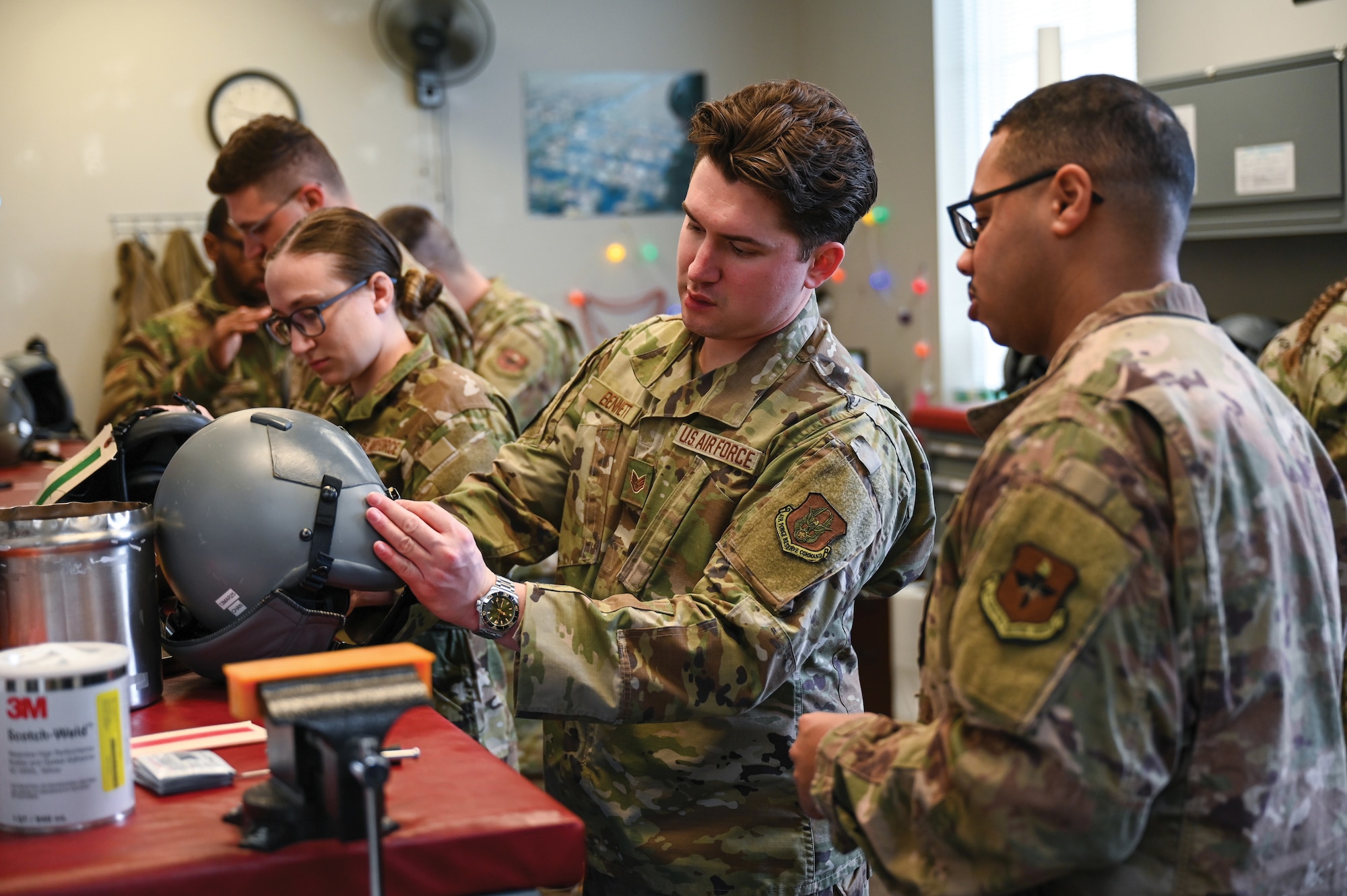 U.S. Air Force Staff Sgt. Jacob Bennett, center, 445th Operations Support Squadron aircrew flight equipment technician, trains Airmen from other Air Force agencies on assembling and inspecting HGU-55/p helmets and MBU-12/P oxygen masks for defects or other damages at Wright-Patterson Air Force Base, Ohio, March 23, 2025. (U.S. Air Force photo by Master Sgt. Patrick O'Reilly)