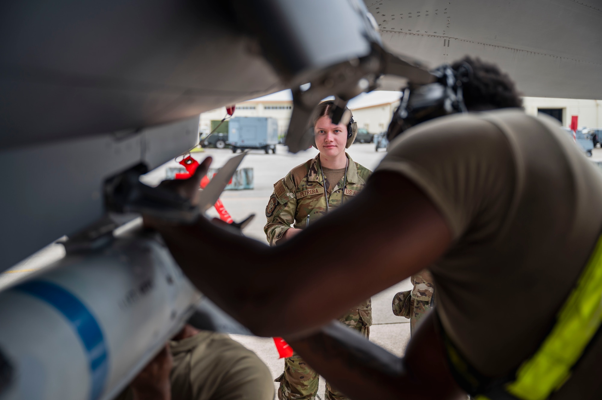 U.S. Air Force Senior Airman Rebecca Petrera, center, 354th Maintenance Squadron weapons load crew member, evaluates Senior Airman Fredarious Martin, 336th Fighter Generation Squadron load crew member