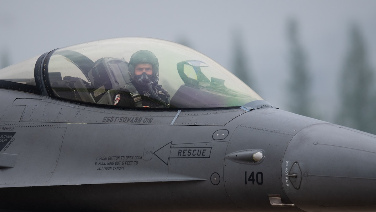 fighter jet looks towards camera from his fighter jet cockpit