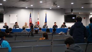 military members sit at a table in an auditorium with media members