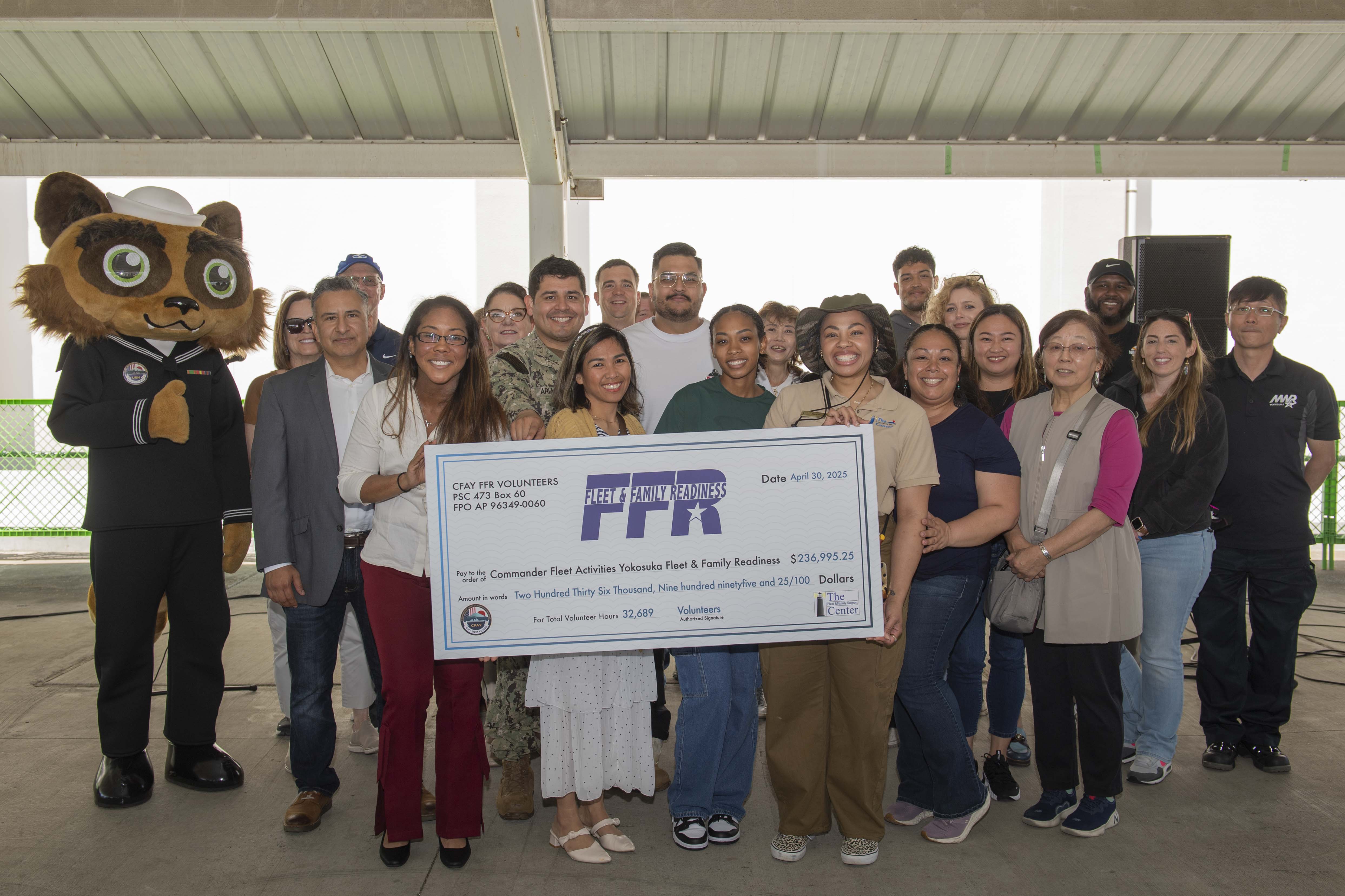 Staff members of the Fleet and Family Support Center and volunteers pose for a photo during a volunteer appreciation ceremony at Commander, Fleet Activities Yokosuka (CFAY) Purdy Gym pavilion.