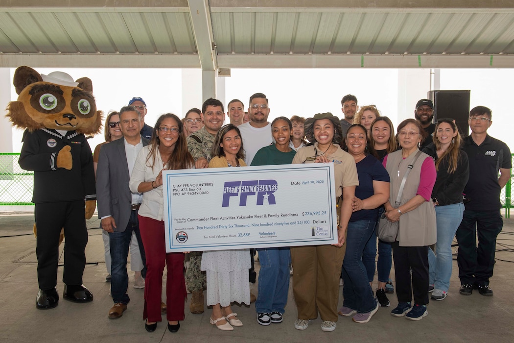 Staff members of the Fleet and Family Support Center and volunteers pose for a photo during a volunteer appreciation ceremony at Commander, Fleet Activities Yokosuka (CFAY) Purdy Gym pavilion.