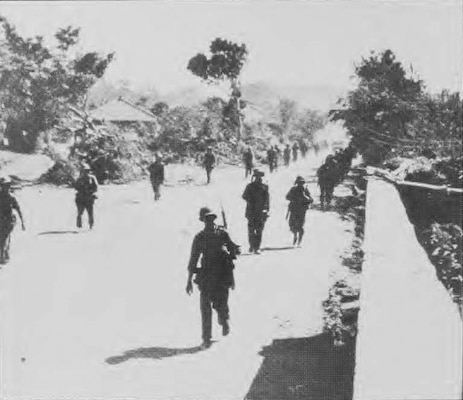 Engineers walk down the street in Post-War Okinawa, Japan