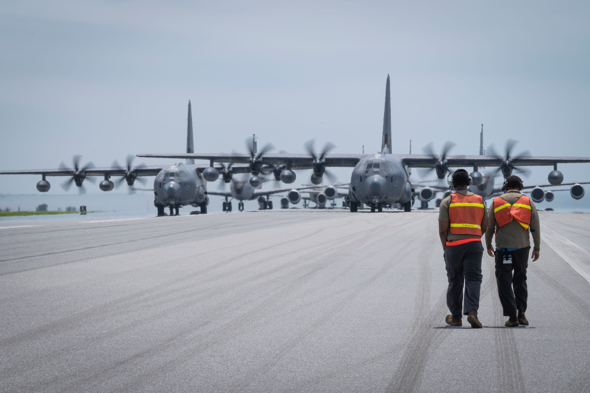 U.S. Air Force Senior Airman Jordan Green, left, 67th Fighter Generation Squadron crew chief, and Staff Sgt. Cameron Young, 67th FGS crew chief walk toward two MC-130J Commando IIs for an elephant walk