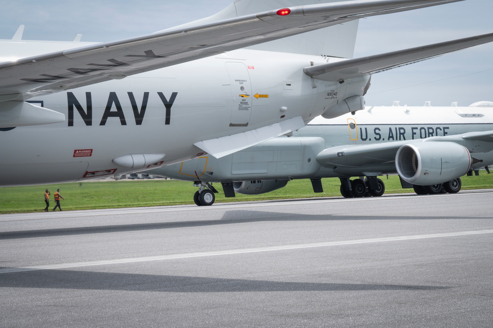 A U.S. Navy P-8 Poseidon and U.S. Air Force RC-135 Rivet Joint line up on the runway for an elephant walk during a routine readiness exercise