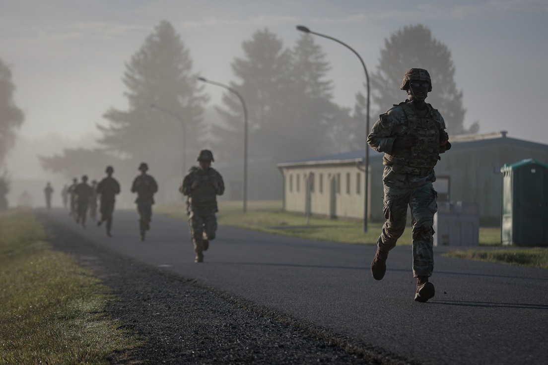 30th Medical Brigade, launches himself over an obstacle during the 21st Theater Sustainment Command Best Squad Competition