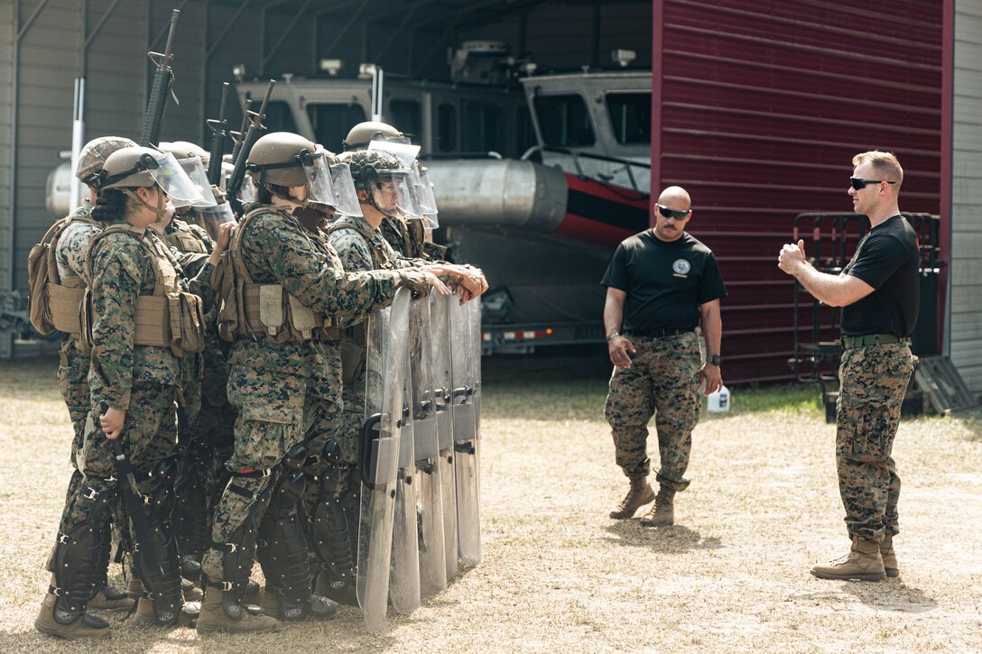 U.S. Marine Corps Capt. Jared Woodward, right, a non-lethal weapons instructor, with the 22nd Marine Expeditionary Unit, instructs during a non-lethal weapons course at Marine Corps Base Stone Bay, April 30th, 2025. The non-lethal weapons course teaches students about weapons that are explicitly designed and primarily employed to incapacitate personnel or materiel while minimizing fatalities, permanent injury to personnel, and undesired damage to property and the environment. (U.S. Marine Corps photo by Cpl. Maurion Moore)