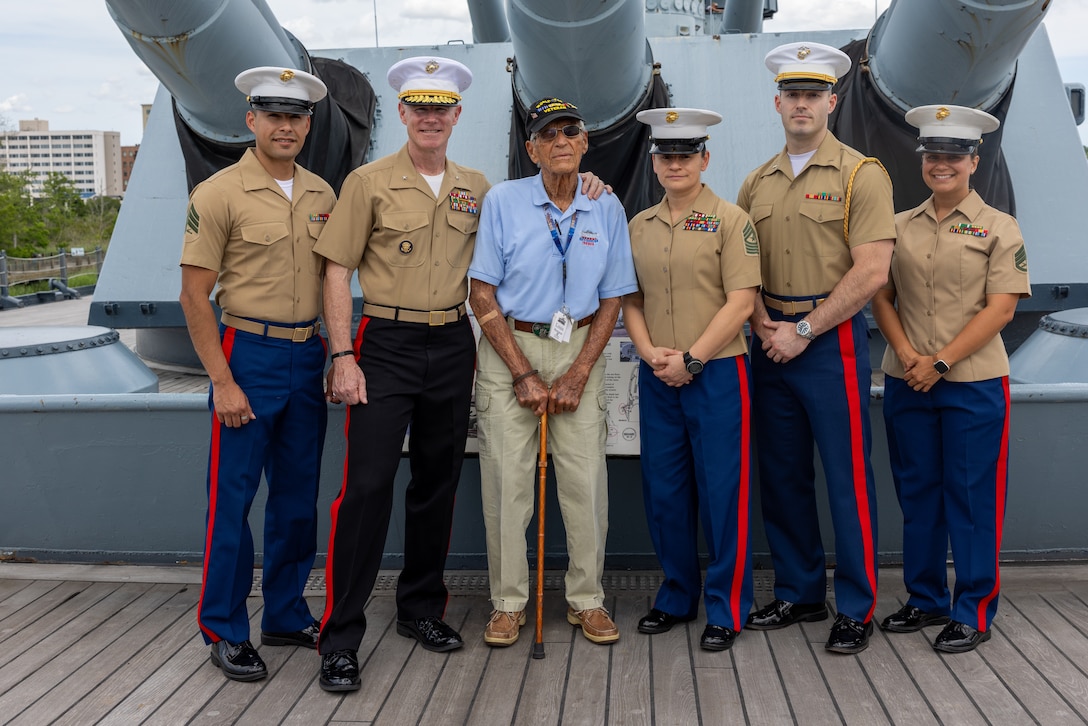 U.S. Marines with II Marine Expeditionary Force pose for a photo with Battle of Iwo Jima veteran Louis Bourgault Jr. following a birthday ceremony aboard the decommissioned battleship USS North Carolina, May 9, 2025. Bourgault, a World War II Marine Corps rifleman, was born on May 9, 1925, and fought in several pivotal battles, including Iwo Jima. The ceremony marked his 100th birthday. (U.S. Marine Corps photo by Cpl. Alexander Lesko)