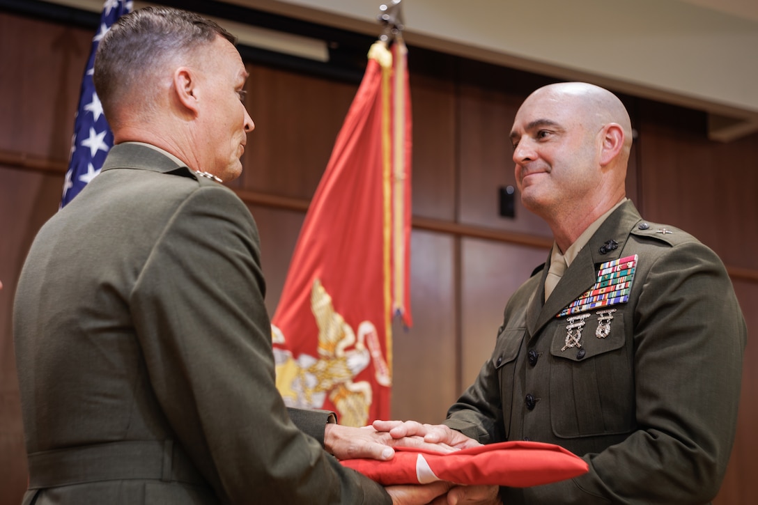 U.S. Marine Corps Col. Joseph A. Katz, the chief of staff for Marine Forces Reserve, receives a flag with 1 star to represent his new rank during a frocking ceremony at Marine Corps Support Facility, New Orleans, May 9, 2025. Frocking is a tradition where Marines are advanced to the next pay grade, assuming the title and the responsibilities prior to their official date of promotion. Katz was frocked to the rank of brigadier general. (U.S. Marine Corps photo illustration by Lance Cpl. Van Hoang)
