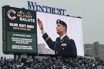 Maj. Scott D. Hager, 85th U.S. Army Reserve Support Command, waves to cheering baseball fans, on the jumbotron, during the Military Salute at the Chicago Cubs Hometown Opener game versus the San Diego Padres on April 4, 2025, at Wrigley Field.