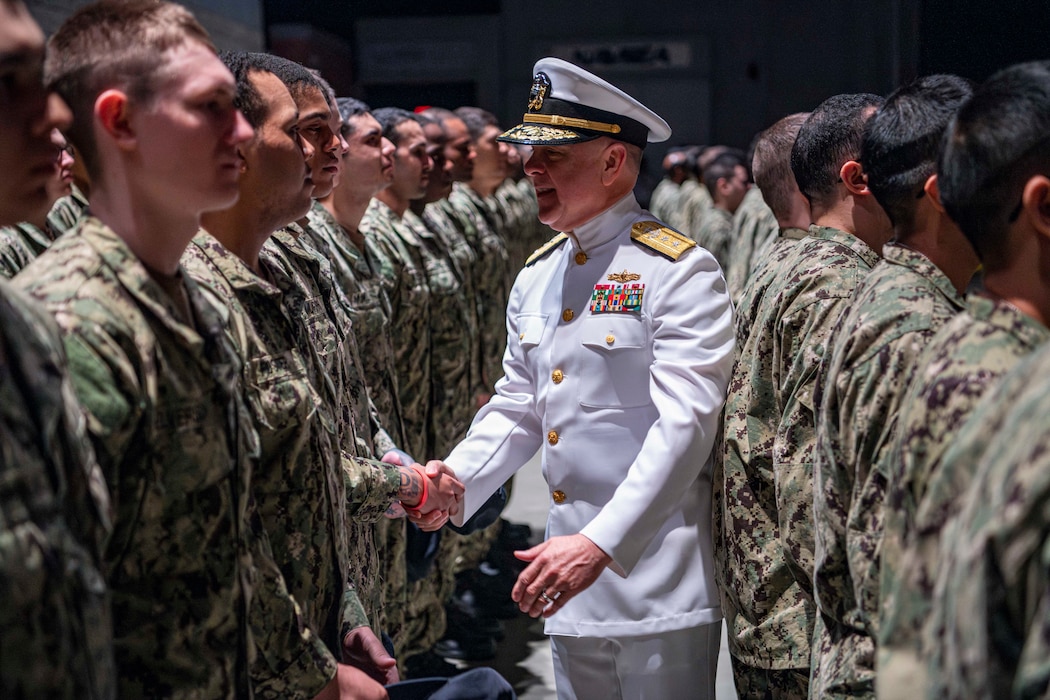 Rear Adm. Kenneth Blackmon, Vice Commander, U.S. Fleet Forces Command, congratulates recruits aboard USS Trayer at Recruit Training Command. Known as "Battle Stations," Trayer is the final test of seamanship, firefighting, and emergency response before graduation.