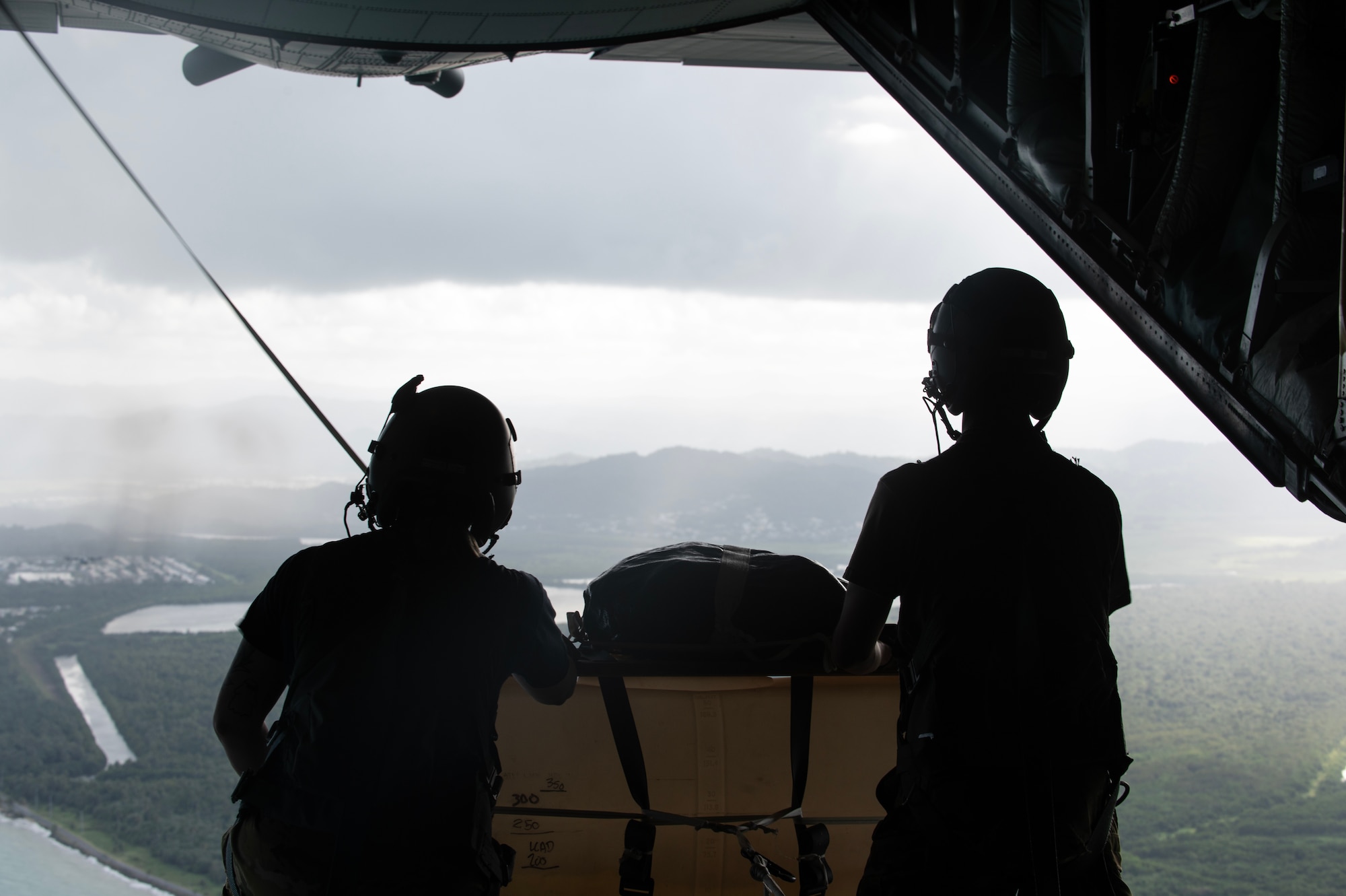 U.S. Air Force Staff Sgt. Haley Stockman, left, and Senior Airman Evan Fleischhacker, right, from the 109th Airlift Squadron, Minnesota Air National Guard, prepare to drop a low-cost, low-altitude (LCLA) bundle in Ceiba, Puerto Rico, April 8, 2025.