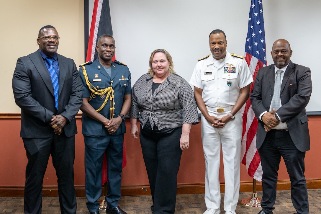 A group of five people pose for a standing group photo.