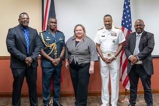A group of five people pose for a standing group photo.