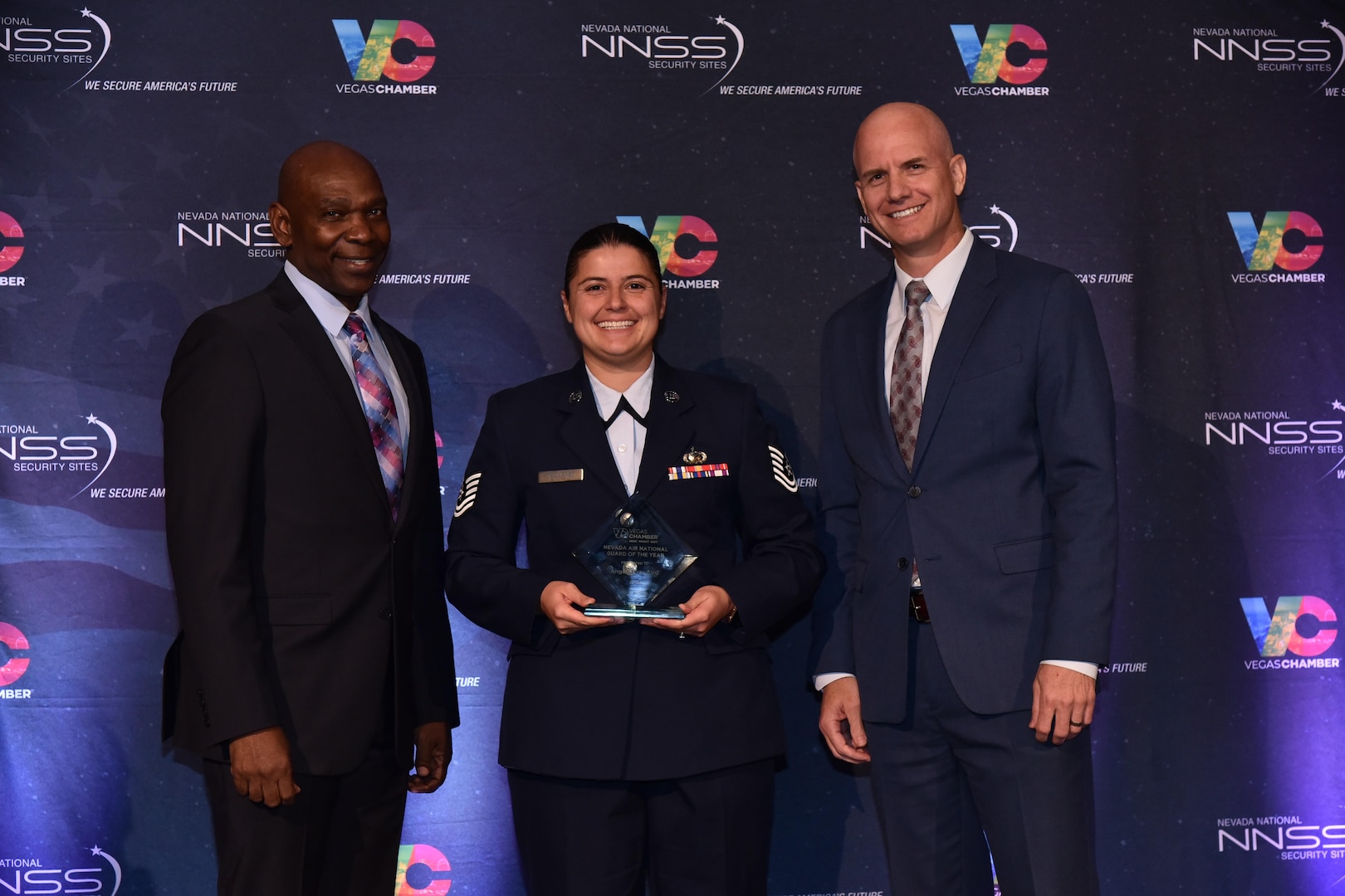 Tech. Sgt. Angela Crawford, center, receives the award for Air Guardsman of the Year from the Las Vegas Chamber during a ceremony at the Westgate Hotel Ballroom in Las Vegas, May 7, 2025. The Las Vegas Chamber recognized three members of the Nevada National Guard during its annual Military Affairs Committee (MAC) Night Out.