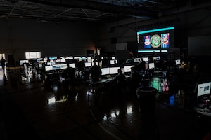 Airmen working on computers in a dark room
