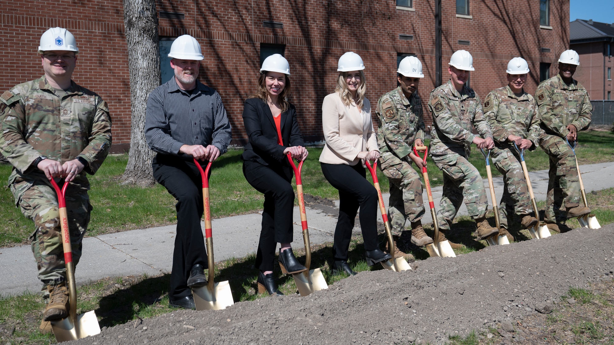 Airmen and civilians assigned to the 319th Reconnaissance Wing, 319th Civil Engineer Squadron and 319th Contracting Squadron pose during a groundbreaking ceremony at Grand Forks Air Force Base, N.D., May, 7, 2025. The construction-industry tradition of the golden shovels celebrates the start of new construction. (U.S. Air Force photo by Airman Nailah Pacheco)