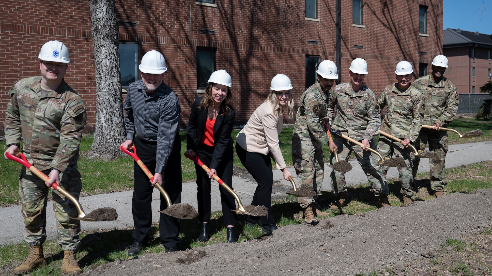 Airmen and civilians assigned to the 319th Reconnaissance Wing, 319th Civil Engineer Squadron and 319th Contracting Squadron break ground during the Bunch Hall dormitory groundbreaking ceremony at Grand Forks Air Force Base, N.D., May 7, 2025. The ceremony celebrated the start of the $14.2 million renovation project that is estimated to take a year to complete. (U.S. Air Force photo by Airman Nailah Pacheco)