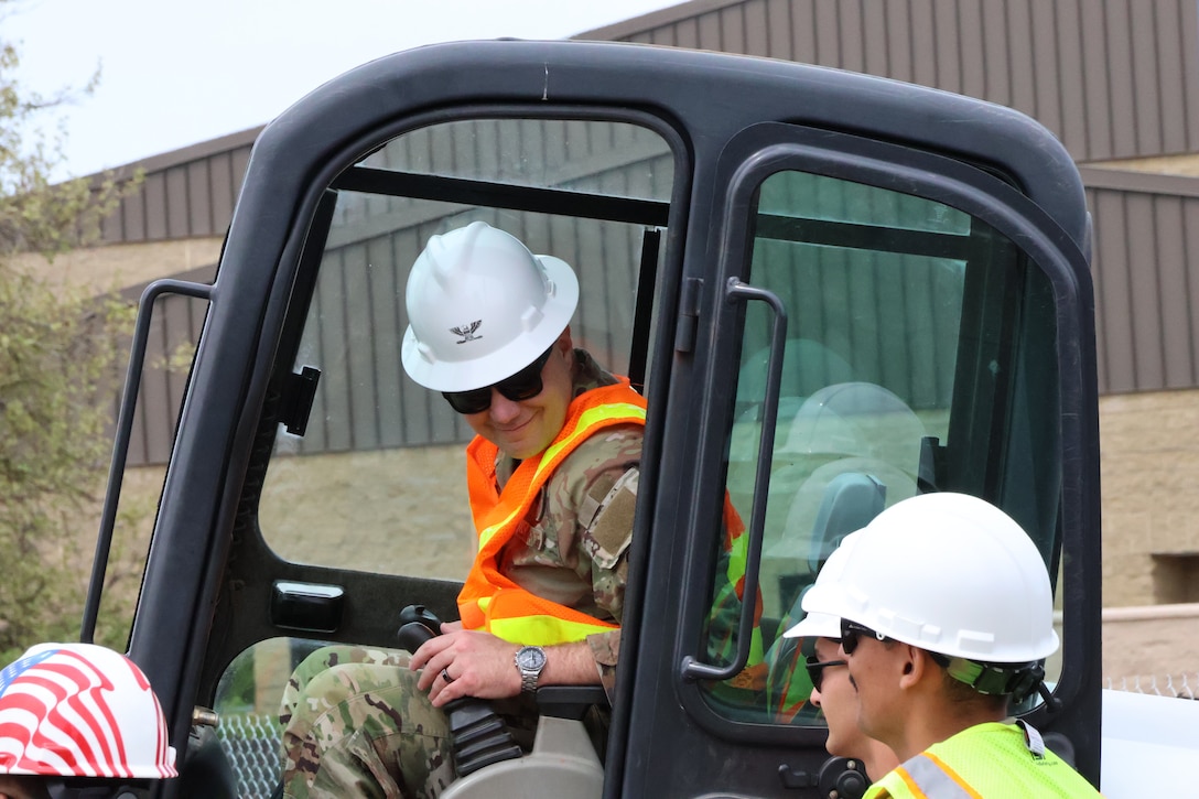 Fairchild commander prepares to tear down small piece of perimeter wall at project site.