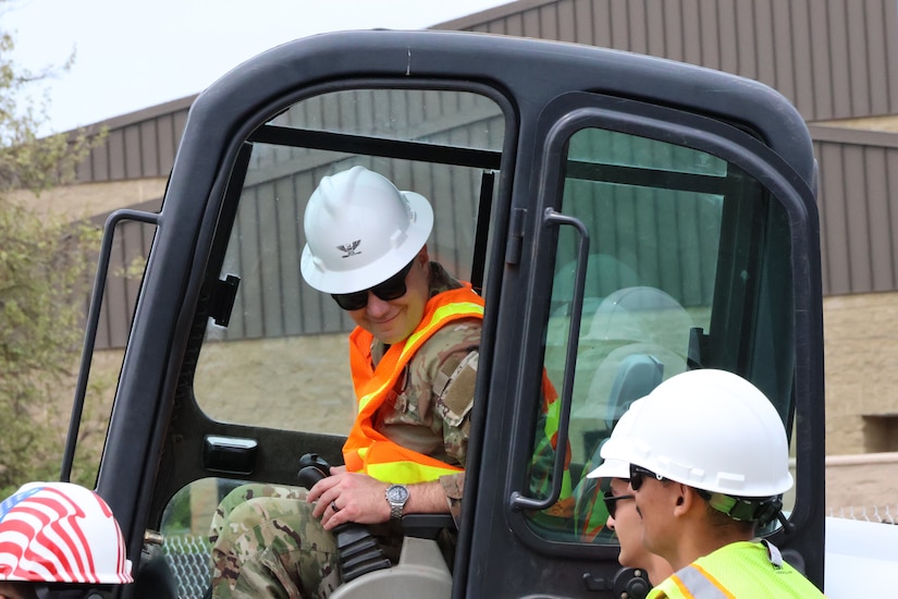Fairchild commander prepares to tear down small piece of perimeter wall at project site.